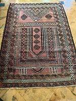 Full view of the rectangular handmade wool carpet showing overall geometric pattern and color.