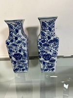 Pair of rectangular blue and white porcelain vases standing side by side showing front floral design.