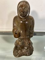 Front view of the signed Inuit carving figurine showing the figure's front details and base texture.