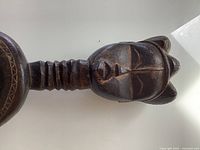 Handle showing carved female head with ridged neck
