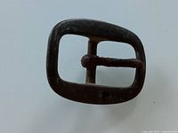 Front view of the antique metal belt buckle showing overall shape and patina