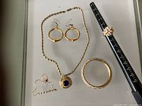 Full lot overview: necklace, earrings, bangle, chain bracelet, pearl ring on mandrel