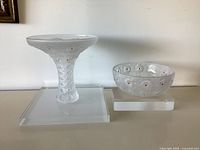 Pedestal vase and bowl displayed side by side on stands