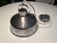 Top view of silver metal dome pendant lamp with attached cord and canopy