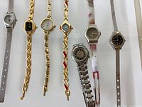 Nine wristwatches lined up showing dials and bracelets