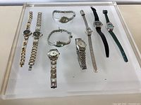 Tray showing nine wristwatches