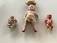 Three dolls laid flat on surface