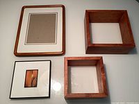 Overview of four frames: teak rectangular, black frame with art, two square shadow boxes