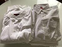 Stacked white dress shirts front view