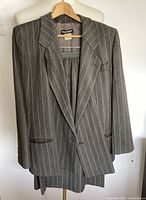 Blazer on hanger over skirt showing overall style and pinstripe pattern