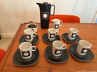 Full set arranged on table showing all pieces including cups, saucers, coffee pot, cream and sugar bowl