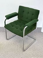 Green tufted cantilever armchair with chrome frame viewed at three-quarter angle showing overall condition.