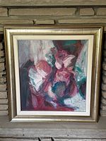 Framed full view of abstract painting with dominant reds and teals.