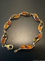 Full bracelet laid flat on dark surface showing all linked sections.