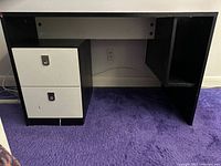 Front view of vintage desk showing black frame and two white drawers with stainless steel handles, scratches visible