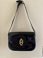 Front view hanging by strap showing flap and overall shape