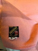 Close-up of the label showing the Trapper Point brand made in England with red and gold details on black background.