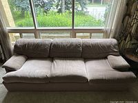 Front view of vintage taupe three-seater sofa showing wide armrests and seat cushions.