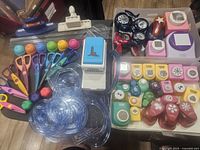 Overview of craft punches, scissors, and circle cutters arranged on table showing variety of colors and sizes