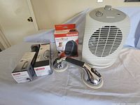 Photo of Holmes white ceramic personal heater, Honeywell Heat Buddy heater in original box, chrome suction cup assist bar.