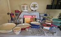 Full view of kitchen and household items including juicer, glassware, bowls, plates, Tupperware and partyware