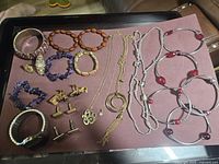 Full assortment of jewelry including bracelets, necklaces, cuff links, rings, watch, and foot chain.
