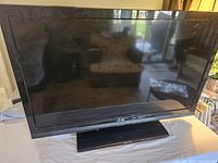 Front view of 39-inch Element LCD TV, turned off, showing black bezel and stand on white surface.