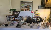Displays various animal figurines, a green desk lamp, glass containers, a minion stuffed animal, monkey coin bank, and multiple decorative knick knacks.