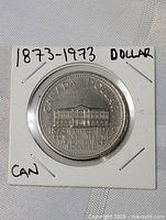 Front side of the 1873-1973 Canada one dollar commemorative coin showing the detailed engraving of the historic building and inscriptions.