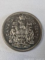 Reverse side of the 1968 Canadian half dollar coin showing coat of arms and denomination.