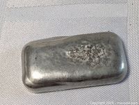 Top view of hand poured pewter ingot showing surface texture and metallic finish