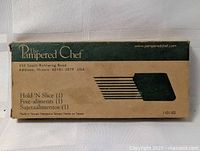 Original cardboard box for The Pampered Chef Hold 'N Slice meat holder fork showing branding and address.