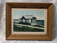 Full view of the framed print showing the oak frame and the pavilion bathhouse scene.