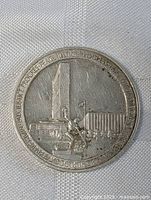 Close-up image of the front side of a vintage Russian silver medallion coin showing architectural designs and inscriptions.