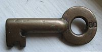 Side view of the vintage brass barrel skeleton key marked C.P.R. and number 8, showing bit and worn condition.