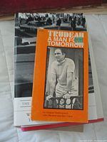 Close-up on the book Trudeau: A Man for Tomorrow with visible orange cover and black and white photo of Pierre Trudeau on the front, atop the other books.