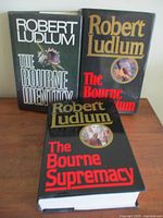 Front covers of three hardcover Bourne Trilogy books by Robert Ludlum showing title and author, all in excellent condition.