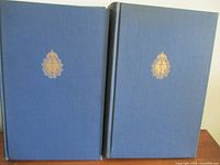 Front covers of both volumes showing blue cloth with gold embossed naval crest.
