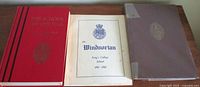 Three vintage books shown: a red hardcover titled The School on the Hill, white hardcover titled The Windsorian, and brownish hardcover covered with a protective strip.