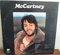 Back cover of Paul McCartney album showing photo of McCartney with child in car and track listing.
