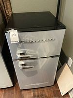 Full front exterior view of compact fridge showing silver finish, chrome handles and Frigidaire script logo