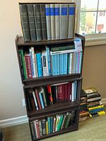 Full view of three-shelf bookcase with bound volumes and paperbacks