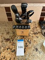 Front view of knife set with knives, shears, honing rod in the wooden block, placed on granite counter.