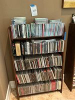 Wooden shelf filled with rows of CD jewel cases