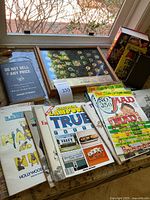 Photo showing assorted vintage magazines and books including Mad Magazine No. 350, National Lampoon, Do Not Sell at Any Price, and others laid out on a table.