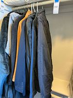 Image showing multiple men's jackets in different colors and styles hung on a rack