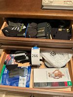 Drawer with boxed Calvin Klein men’s boxer briefs size XL, performance no-show socks in packaging, and other assorted socks in white, black, and gray.