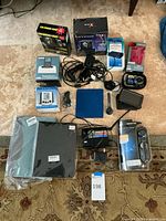 Full view of all electronics and accessories laid out on floor showing boxed and loose items, including camera, GPS, chargers, cables, and cases.