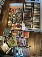 Overview of two banker’s boxes filled with stacked PC game discs and loose cases on floor
