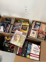 Overall lot of vintage PC games, software, and music CDs displayed in open boxes showing various titles including Adobe Illustrator, PC Games Magazine, Polish-English dictionary, and boxed games.